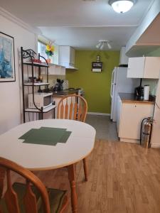 una cucina con tavolo e sedie in una stanza di logement,suite l arlequin a Vaudreuil-Dorion