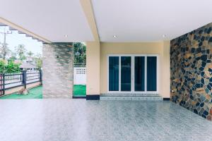 una stanza con una porta e un muro di pietra di AABAN House 03 a Hat Yai