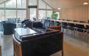 a restaurant with couches and a bar with tables and chairs at Nice Home In Kpingsvik With Sauna in Grönskog