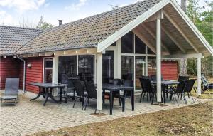 pawilon ze stołami i krzesłami na patio w obiekcie Nice Home In Kpingsvik With Sauna w mieście Grönskog