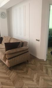 un soggiorno con divano e pavimento in legno di pialo a Paposhvilebi