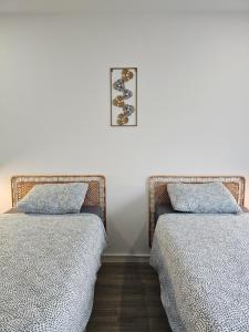 dos camas sentadas una al lado de la otra en un dormitorio en Appart'Hôtel Trazegnies, en Courcelles