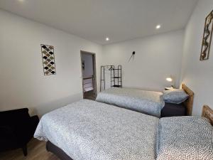 1 dormitorio con 2 camas individuales y 1 silla en Appart'Hôtel Trazegnies, en Courcelles