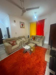 uma sala de estar com dois sofás e um tapete vermelho em Maimoon homes em Malindi
