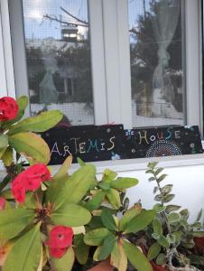 una ventana con un cartel que diga casa de emergencia en Artemis House en Agios Nikolaos
