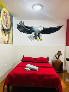 a bedroom with a red bed with an eagle on the wall at Casa BB&Djassi in Ponta do Sol