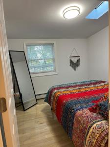 a bedroom with a bed with a colorful blanket at Schunemunk Mnt hse 15 mins to Legoland &woodbury in Monroe