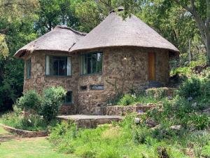a small stone house with a grass roof at Forestiva Farm - River Cottage in Centurion