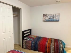 a bedroom with a bed with a colorful blanket at Schunemunk Mnt hse 15 mins to Legoland &woodbury in Monroe