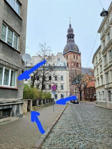 una strada cittadina con frecce blu di fronte a un edificio di City Inn 3 bedrooms Apartment next to Dom square a Riga