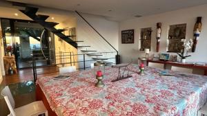 a dining room with a table with a flowered table cloth at La LUNA of MARSEILLE - VILLA D'ARCHITECTE B&B in Marseille