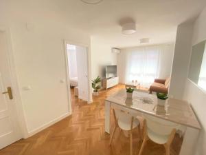 a kitchen and living room with a table and chairs at Apartamento Las Rozas centro con Parking incluido in Las Rozas de Madrid