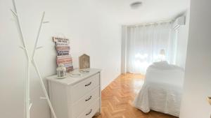 een witte slaapkamer met een bed en een dressoir bij Apartamento Las Rozas centro con Parking incluido in Las Rozas de Madrid