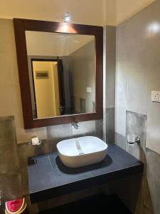 a bathroom with a sink and a large mirror at SOHA Home Stay in Galle