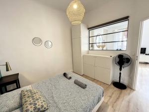 - une chambre avec un lit, une fenêtre et un ventilateur dans l'établissement PLACE - Appartement lumineux au coeur de la Joliette, à Marseille