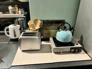 a tea kettle is sitting on top of a toaster at Weaver Place in Bloubergstrand