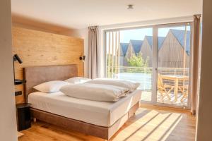 a bedroom with a bed and a large window at Aparthotel Parsberg GreenDesign in Parsberg