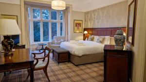 a hotel room with a bed and a desk and a desk at Ambleside Manor - Vegetarian B&B in Ambleside