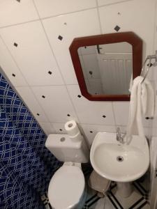 een badkamer met een toilet, een wastafel en een spiegel bij Casa paraíso Paraty in Paraty