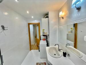 a white bathroom with a sink and a mirror at Apartment City Park, 24H Checkin & City Centre w Free Parking in Piešťany