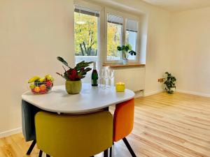 uma sala de jantar com uma mesa com cadeiras e uma janela em Apartment City Park, 24H Checkin & City Centre w Free Parking em Piešťany
