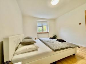 a bedroom with a large white bed with a window at Apartment City Park, 24H Checkin & City Centre w Free Parking in Piešťany