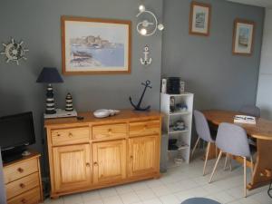 a room with a wooden cabinet and a table and a television at Appartement Saint-Cyprien, 3 pièces, 6 personnes - FR-1-106-44 in Saint-Cyprien