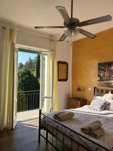 um quarto com uma cama, uma ventoinha de tecto e uma varanda em Le Giare House em Grezzana