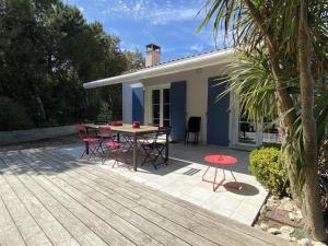 patio ze stołem i krzesłami oraz dom w obiekcie Villa bord de mer, 10 pers, 5 chbres, proche plage, jardin privé, Wifi, animaux ok - FR-1-246A-207 w mieście Saint-Georges-dʼOléron
