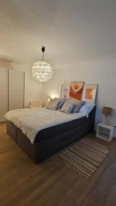 a bedroom with a bed and a chandelier at Appartement Les Salines in Roche