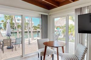 - un salon avec une table, des chaises et une télévision dans l'établissement R & R Retreat, à Key Colony Beach