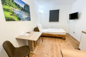 a room with a desk and a table and a bed at Good Sleep - Appartments in Irxleben
