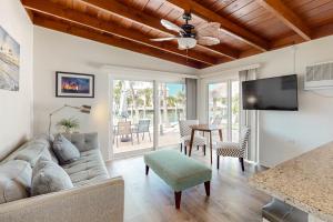 a living room with a couch and a flat screen tv at R & R Retreat in Key Colony Beach