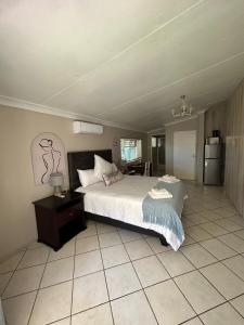 ein Schlafzimmer mit einem großen Bett und Fliesenboden in der Unterkunft 9 wena Ave Guesthouse in Klerksdorp