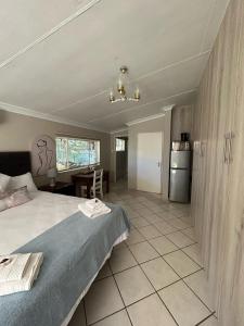 1 Schlafzimmer mit einem großen Bett und einer Küche in der Unterkunft 9 wena Ave Guesthouse in Klerksdorp