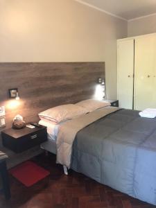 1 dormitorio con 1 cama grande y cabecero de madera en CasaFélix en Mendoza
