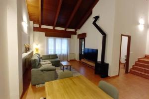 ein Wohnzimmer mit Sofa und Tisch in der Unterkunft Dúplex rodeado de naturaleza, bodegas e historia in Sojuela