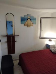 Schlafzimmer mit einem roten Bett und einem Spiegel in der Unterkunft MER, BATEAUX, Canaux in Sète
