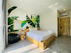 a bedroom with a bed with a painting on the wall at Hill Star Hotel Phu Quoc in Phu Quoc
