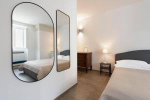 1 dormitorio con espejo grande y cama en MOH - Casa Vacanze, en Grottaglie