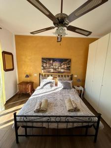 a bedroom with a large bed with a ceiling fan at Le Giare House in Grezzana