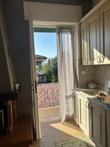 a kitchen with a door open to a patio at Le Giare House in Grezzana