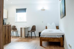 a bedroom with a bed and a table and chairs at Good Sleep - Appartments in Irxleben