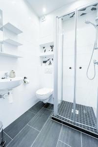 a white bathroom with a shower and a toilet at Good Sleep - Appartments in Irxleben