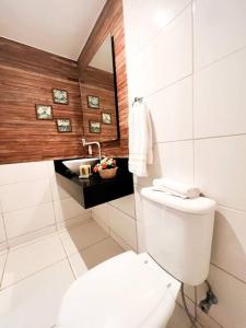 a white bathroom with a toilet and a sink at Paraíso de luxo: sua casa dos sonhos in Angra dos Reis