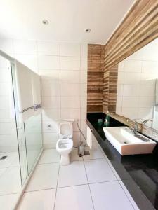 a bathroom with a toilet and a sink at Paraíso de luxo: sua casa dos sonhos in Angra dos Reis