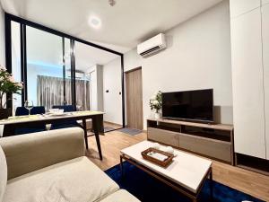 a living room with a couch and a table at Luxury Astra Sky River in Chiang Mai