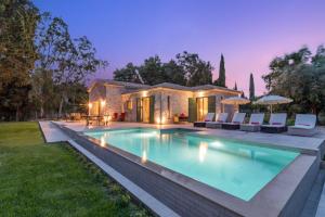 a swimming pool in front of a house at Astarte Villas - Laalu Private Villa with Pool in Koukounariá