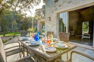 een tafel met borden en glazen op een patio bij Astarte Villas - Laalu Private Villa with Pool in Koukounariá