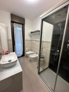 a bathroom with a sink and a shower and a toilet at Sempione Apartment in Lainate